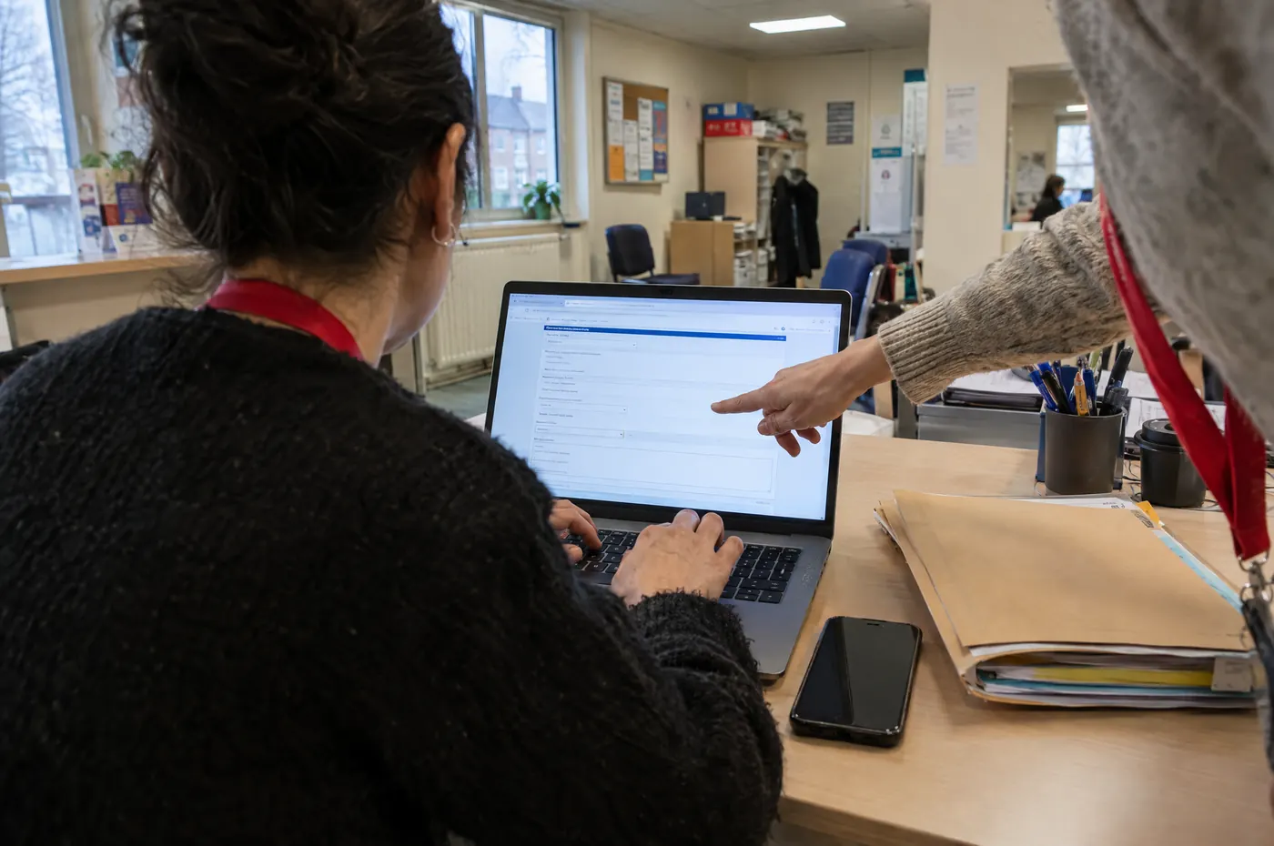 Une travailleuse sociale remplit une demande en ligne avec l'aide d'une médiatrice