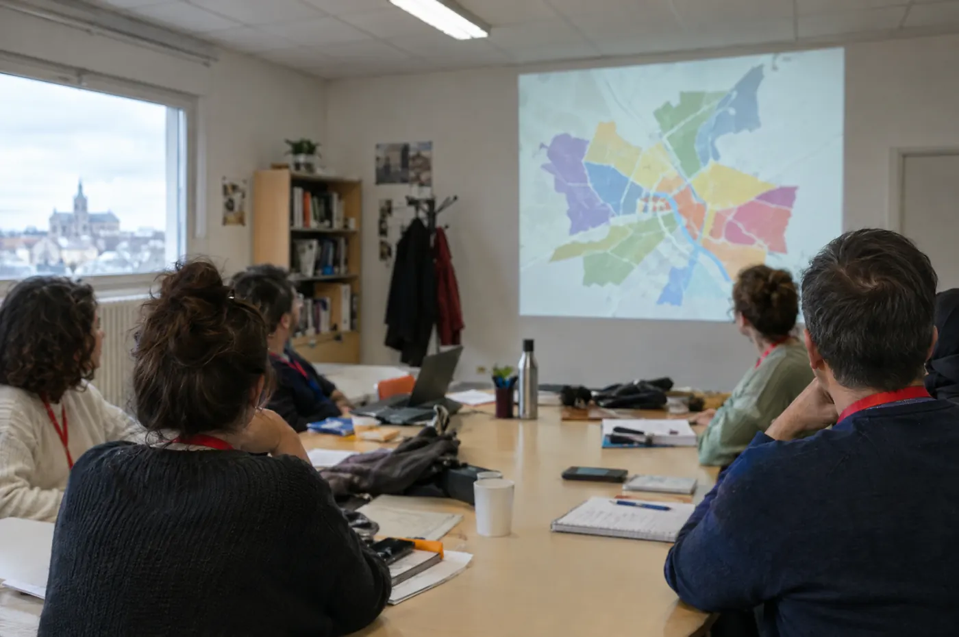 Réunion de partenaires autour d'une carte des quartiers
